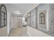Bright hallway with decorative mirrors, tile flooring, and arched window, leading to a white living room at 2486 Indian E Trl, Palm Harbor, FL 34683