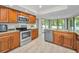 Well-lit kitchen features wood cabinetry, granite countertops, stainless steel appliances, and backyard views at 2486 Indian E Trl, Palm Harbor, FL 34683