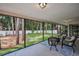 Screened-in lanai featuring neutral tile flooring with a seating arrangement and a view of the private backyard at 2486 Indian E Trl, Palm Harbor, FL 34683