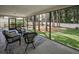 Screened porch overlooking fenced yard with trees, perfect for outdoor living and relaxation at 2486 Indian E Trl, Palm Harbor, FL 34683