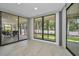 Bright sunroom featuring tile floors, floor-to-ceiling windows, and views of the backyard and screened-in porch at 2486 Indian E Trl, Palm Harbor, FL 34683