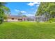 A sprawling backyard with a pool and solar panels on the roof of the house at 251 Dunbridge Dr, Palm Harbor, FL 34684