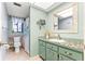 Mint green bathroom featuring decorative mirror and vanity with tiled counter at 251 Dunbridge Dr, Palm Harbor, FL 34684