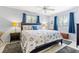 Bright bedroom featuring a ceiling fan, tile floors, and a beach-themed bed set at 251 Dunbridge Dr, Palm Harbor, FL 34684