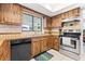 View of a galley kitchen with unique wood cabinets and modern stainless steel appliances at 251 Dunbridge Dr, Palm Harbor, FL 34684