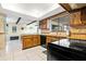 Well-lit kitchen featuring light tile flooring, wooden cabinetry and black appliances at 251 Dunbridge Dr, Palm Harbor, FL 34684