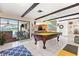 Spacious living room with a billiards table and a view of the screened-in pool at 251 Dunbridge Dr, Palm Harbor, FL 34684