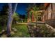 Beautifully landscaped yard with manicured hedges, palm trees, and exterior lighting highlighting a home at 2536 Burlington N Ave, St Petersburg, FL 33713