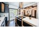 Open kitchen featuring modern island with stove, stainless appliances, dark cabinets, and hardwood floors at 2536 Burlington N Ave, St Petersburg, FL 33713
