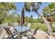 Outdoor deck featuring a glass table, 6 chairs, umbrella, and a beautiful tree-lined view at 2613 59Th S St, Gulfport, FL 33707