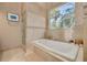 Bathroom features a soaking tub with a picture window and a walk-in shower at 2613 59Th S St, Gulfport, FL 33707