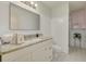 White bathroom features a granite vanity, white cabinets, and combined shower and toilet area at 2613 59Th S St, Gulfport, FL 33707