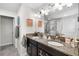 Bathroom featuring double sinks, granite countertops, a large mirror, and a view of the walk-in shower at 28638 Tranquil Lake Cir, Wesley Chapel, FL 33543