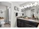 Well-lit bathroom with granite countertops, double sinks, framed mirrors, and tiled floors at 28638 Tranquil Lake Cir, Wesley Chapel, FL 33543