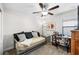 Bedroom with a daybed, ceiling fan, and wooden desk, illuminated by natural light at 28638 Tranquil Lake Cir, Wesley Chapel, FL 33543