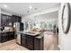 Well-lit kitchen featuring an island with seating, granite countertops, stainless steel appliances, and hardwood floors at 28638 Tranquil Lake Cir, Wesley Chapel, FL 33543