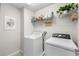 Functional laundry room equipped with a washer, dryer, and shelving, providing convenience and organization at 28638 Tranquil Lake Cir, Wesley Chapel, FL 33543