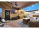 Inviting covered patio with string lights, comfortable seating, and outdoor television at 28638 Tranquil Lake Cir, Wesley Chapel, FL 33543