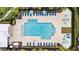 Aerial view of a community pool area with lounge chairs and umbrellas at 28638 Tranquil Lake Cir, Wesley Chapel, FL 33543
