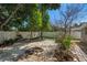 Private backyard with a gravel area, stone firepit, white fence, mature trees, and brick patio at 2903 W Paxton Ave, Tampa, FL 33611