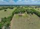 Aerial view of house and acreage with long driveway winding through fields and mature trees at 35657 Ashley Ln, Dade City, FL 33523