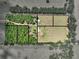 A birds-eye view of a large, partially-wooded acreage property showcasing the house and outbuildings at 35657 Ashley Ln, Dade City, FL 33523