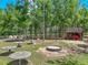 Expansive backyard featuring a fire pit, picnic tables and a covered tractor shed with a tractor parked inside at 35657 Ashley Ln, Dade City, FL 33523