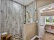 Tiled shower in bathroom with pebble floor, glass enclosure and wooden stool at 35657 Ashley Ln, Dade City, FL 33523