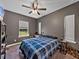 This inviting bedroom features a ceiling fan and a view of the outdoors at 35657 Ashley Ln, Dade City, FL 33523