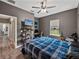 Cozy bedroom boasts a ceiling fan, large windows, and a well-organized workspace at 35657 Ashley Ln, Dade City, FL 33523
