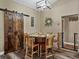 Dining room features a unique round table, seating for six, and a decorative sliding barn door at 35657 Ashley Ln, Dade City, FL 33523