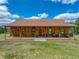 Charming single-story home with a full-length porch and inviting red front door at 35657 Ashley Ln, Dade City, FL 33523