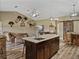 Open-concept kitchen features a large island with seating, a view into the living room, and modern light fixtures at 35657 Ashley Ln, Dade City, FL 33523