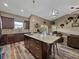 Open-concept kitchen boasts a large island, granite counters, stainless steel appliances, and adjacent seating area at 35657 Ashley Ln, Dade City, FL 33523