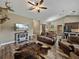 Open concept living room with wood floors, vaulted ceiling and view to the dining and kitchen areas at 35657 Ashley Ln, Dade City, FL 33523