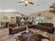 Spacious living room open to the kitchen and dining area, featuring wood floors and a vaulted ceiling at 35657 Ashley Ln, Dade City, FL 33523
