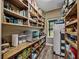 Spacious pantry with custom wooden shelving providing ample storage and organization, plus a window for natural light at 35657 Ashley Ln, Dade City, FL 33523