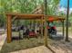 Wood-framed shed storing a tractor and other various landscaping equipment at 35657 Ashley Ln, Dade City, FL 33523