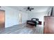 Comfortable bedroom with gray wood floors, ceiling fan, and ensuite bath at 3605 W Anderson Ave, Tampa, FL 33611