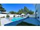 Outdoor pool with brick patio and furniture, surrounded by a white privacy fence and lush greenery at 3605 W Anderson Ave, Tampa, FL 33611