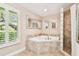 Relaxing bathroom featuring a soaking tub, tiled shower, and large window with plantation shutters at 4106 Queller Way, Tampa, FL 33618