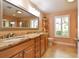 Bathroom featuring a double vanity with granite countertop, and a large mirror, exuding elegance and functionality at 4106 Queller Way, Tampa, FL 33618