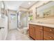 Functional bathroom with a glass-enclosed shower, wood vanity, and convenient access to the outdoors at 4106 Queller Way, Tampa, FL 33618