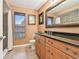 Cozy bathroom with granite countertops, bronze fixtures, and a tiled shower with a glass door at 4106 Queller Way, Tampa, FL 33618