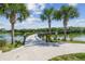 Scenic boardwalk extends over a calm lake, framed by lush greenery and clear skies at 4106 Queller Way, Tampa, FL 33618