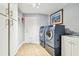 Well-lit laundry room with modern washer and dryer, ample cabinet space, and convenient sink at 4106 Queller Way, Tampa, FL 33618