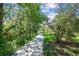 Idyllic walking path lined with lush greenery and dappled sunlight creates a peaceful outdoor experience at 4106 Queller Way, Tampa, FL 33618