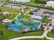 Aerial view of a colorful playground with various play structures, picnic areas, and lush green spaces at 4106 Queller Way, Tampa, FL 33618