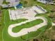Aerial view of skate park features ramps, rails, and a looped pump track with lights and parking at 4106 Queller Way, Tampa, FL 33618
