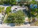 Aerial view of a home with a damaged roof surrounded by lush greenery and other structures at 4111 W Marietta St, Tampa, FL 33616